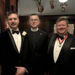 Father Pyles flanked on both sides by members of the St. George's Society of Baltimore